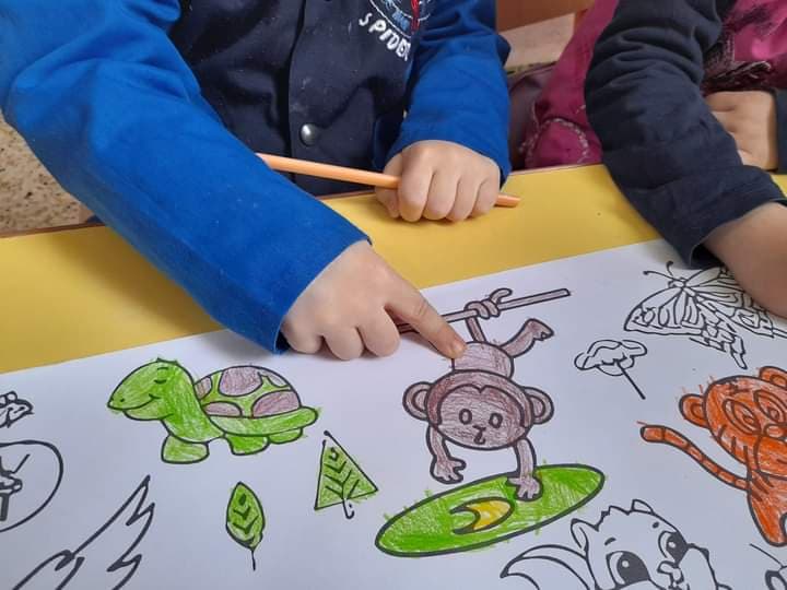 A child coloring an animal worksheet with focus
